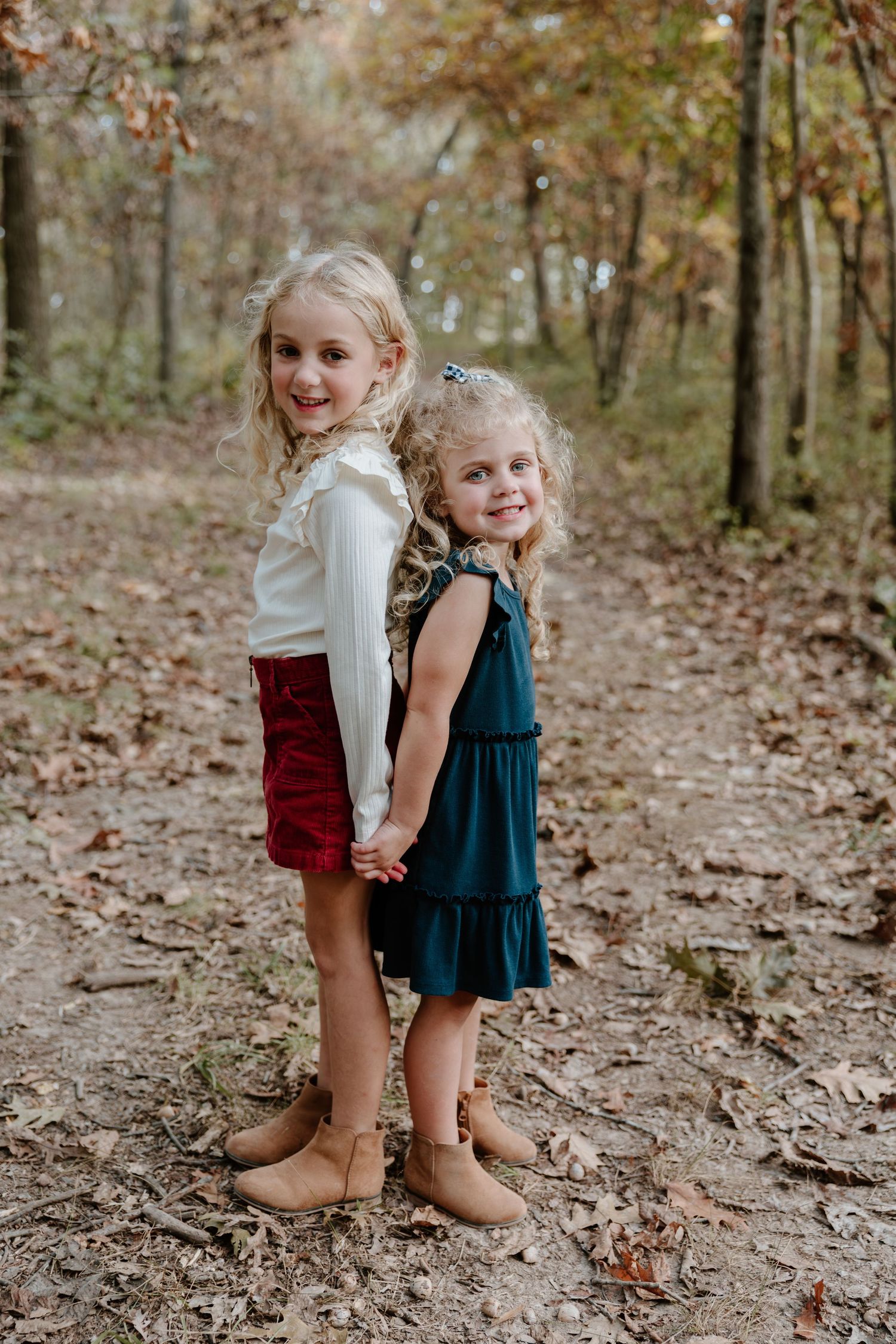 A sequence of playful moments showing a child in a teal dress and brown boots on a leaf-covered forest path.