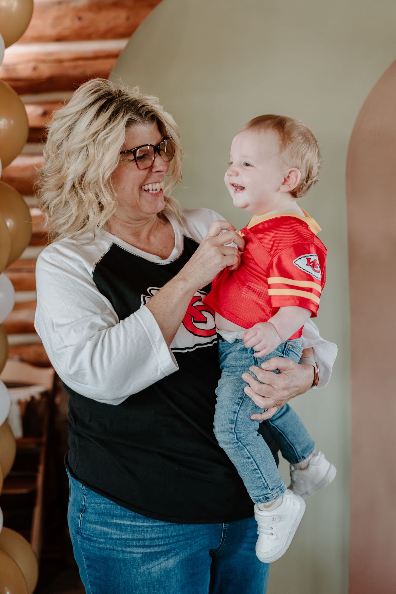 A series of candid moments showing playful interaction between an adult in black and white and a baby in red.