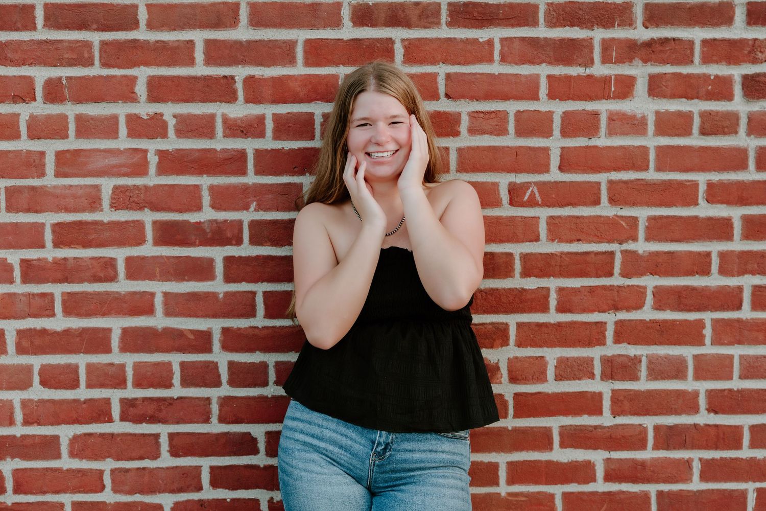 A sequence of four photos against a brick wall showing expressive hand gestures and poses in casual attire.
