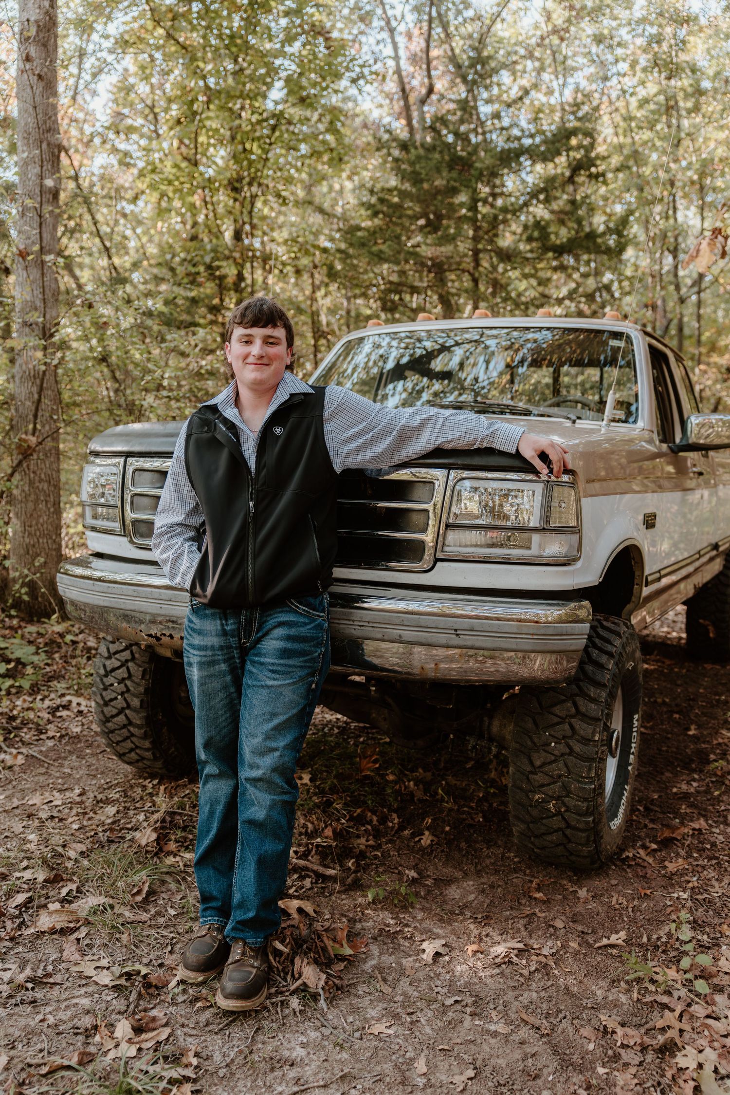 A series of photos showing someone posing playfully near an old abandoned car in a wooded area.