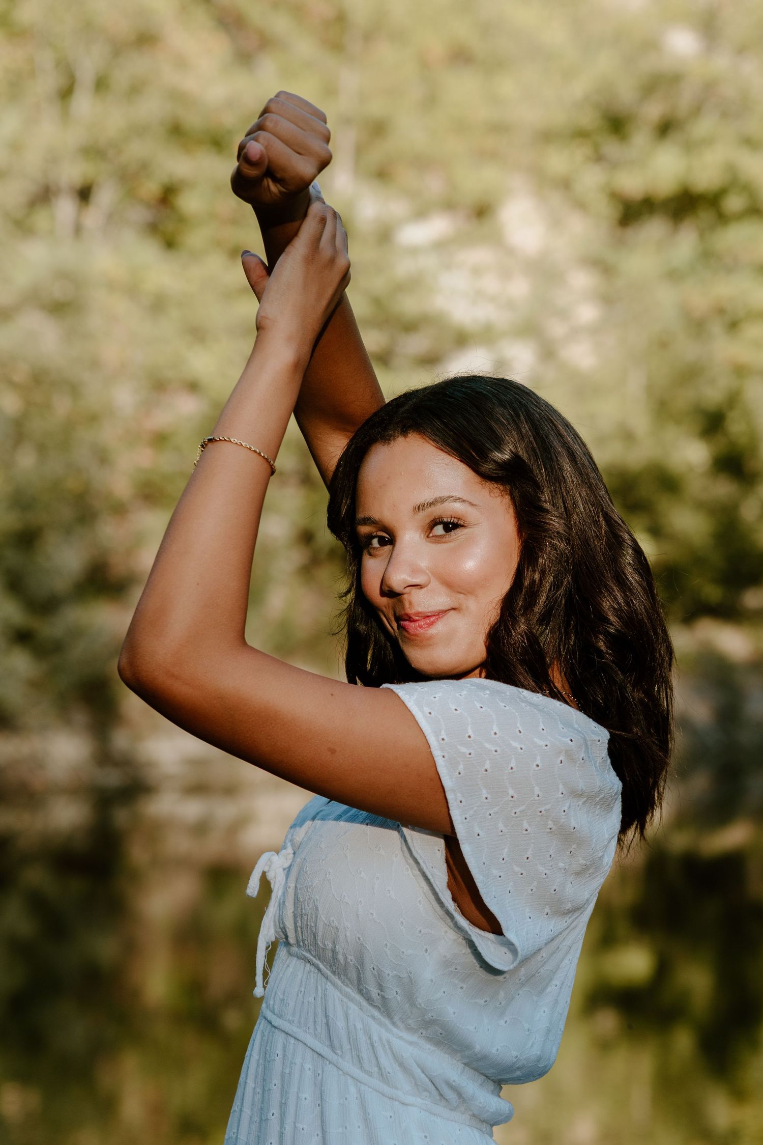 A person in a light gray shirt poses playfully in a sequence of outdoor photos near a reflective lake.