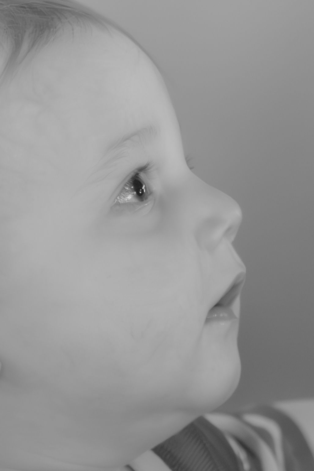 Close-up profile view of a baby's face in black and white showing delicate features and soft skin.