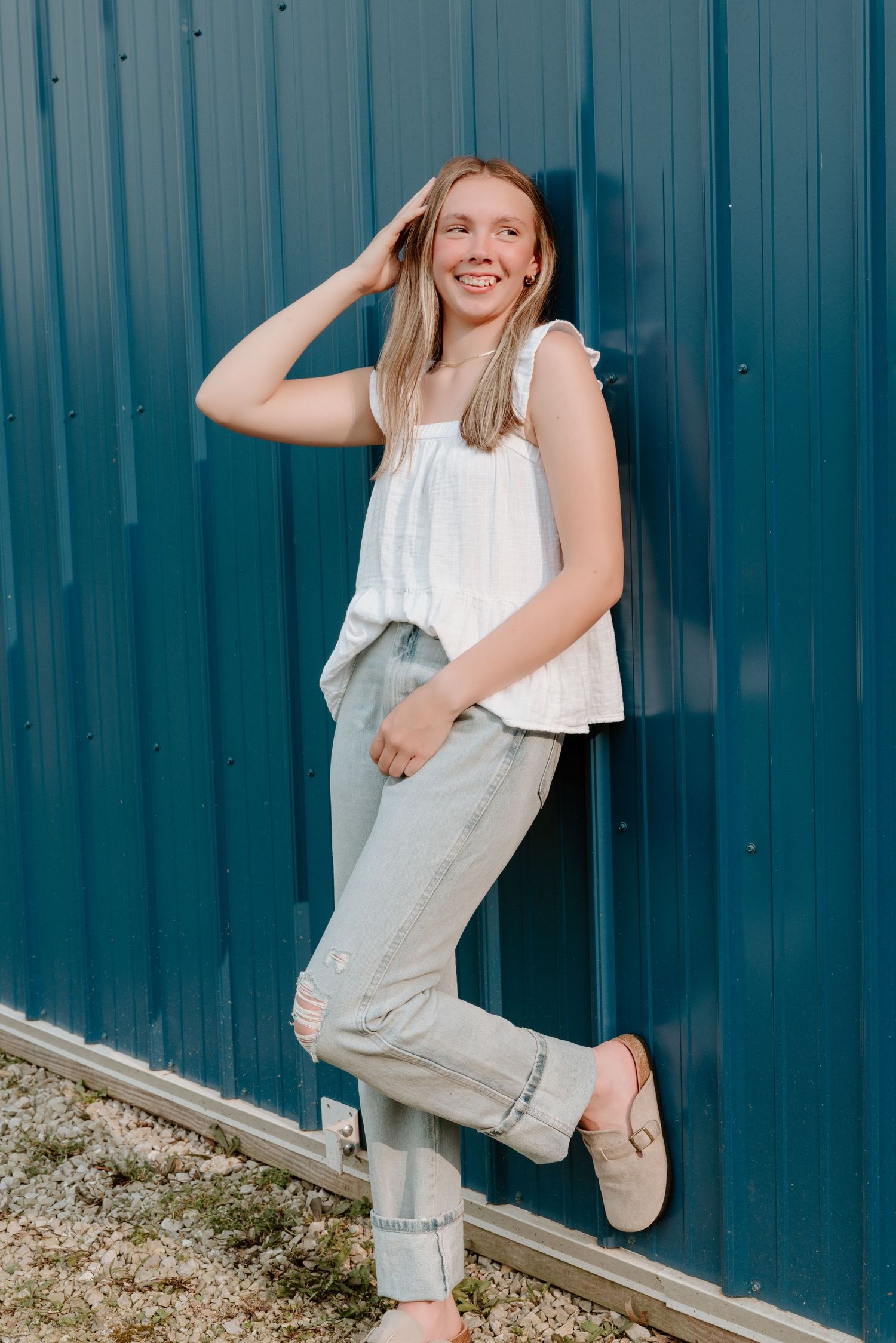 Playful portrait series against a turquoise metal wall in casual summer attire.