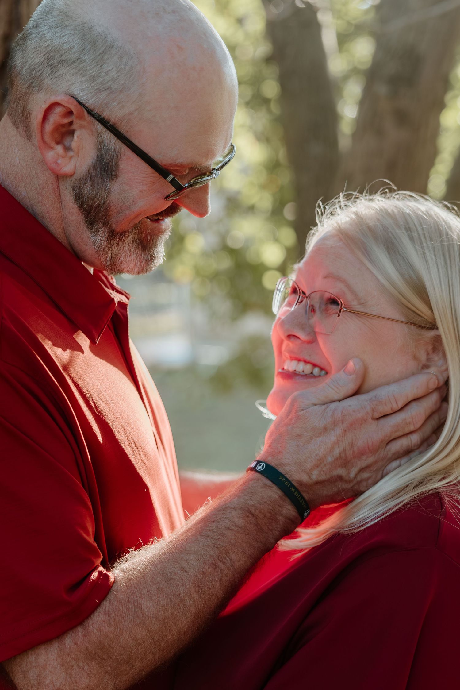 A couple in red and white share tender moments in a series of intimate outdoor portraits at sunset.