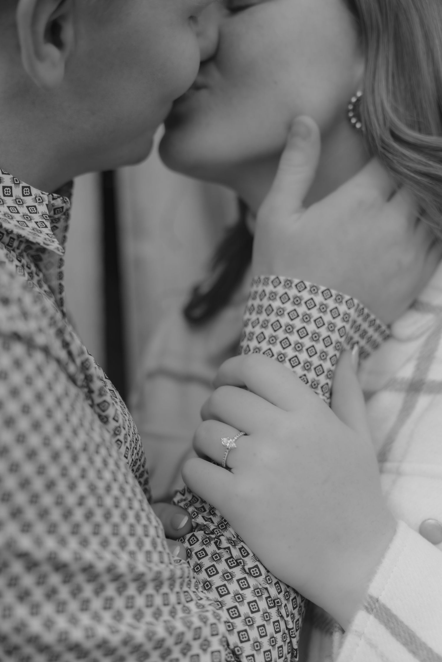 Close-up black and white sequence of a romantic kiss between two people in patterned clothing.