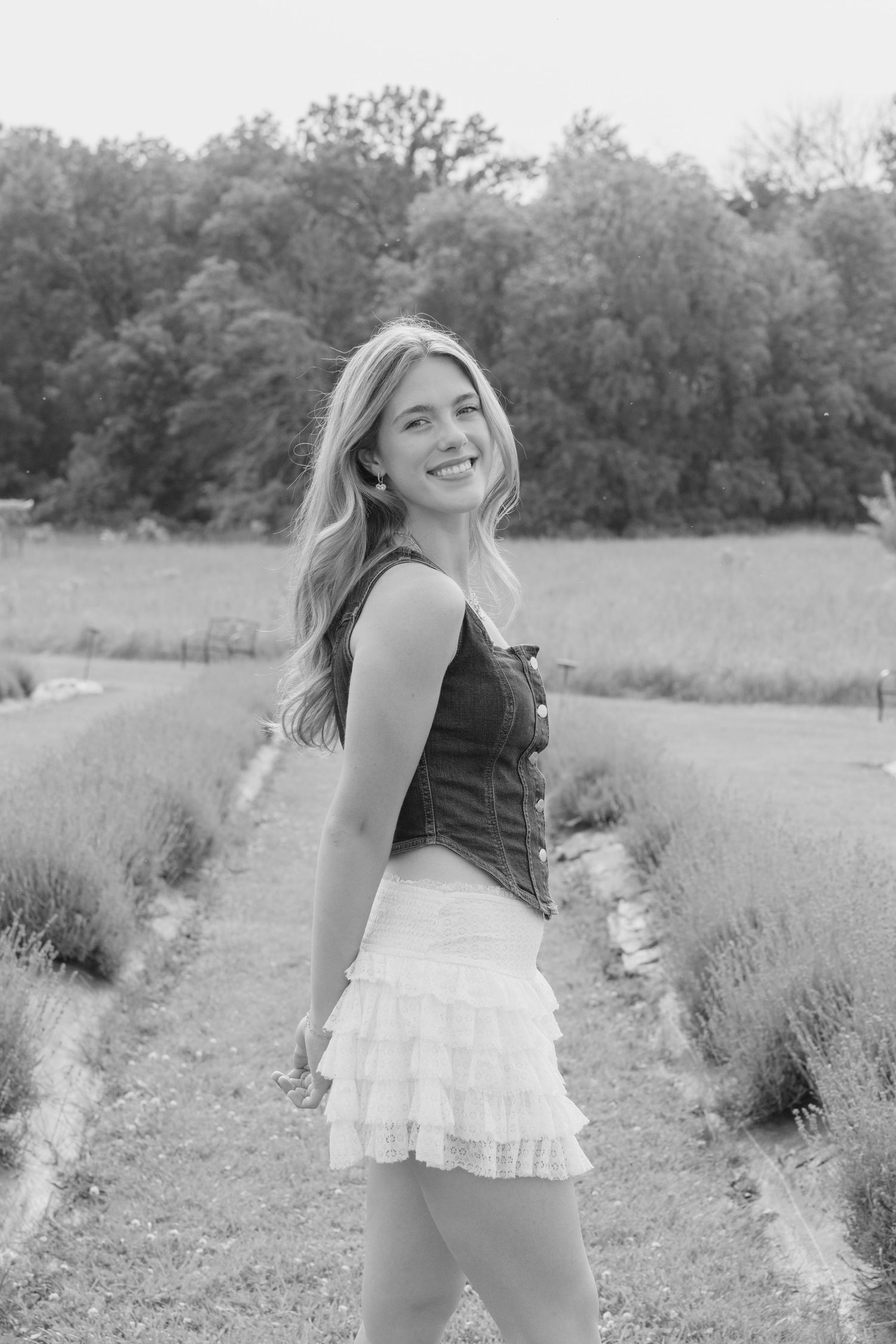 Black and white portrait among lavender plants featuring casual summer style with ruffled skirt and tank top.