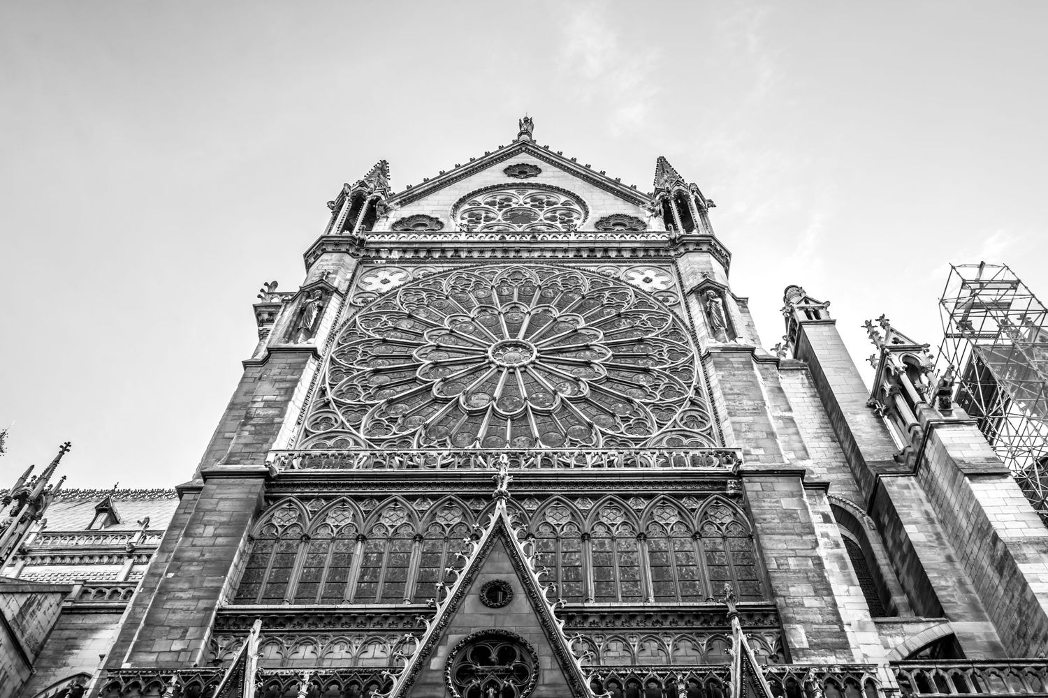 Black and white photo of Notre-Dame Cathedral facade featuring the iconic rose window and Gothic architecture.