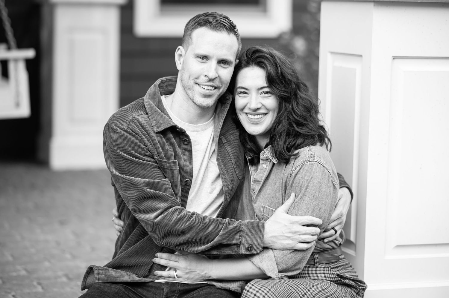 a husband and wife pose together for a portrait on the porch of their Morgantown, WV home during a fall family portrait session