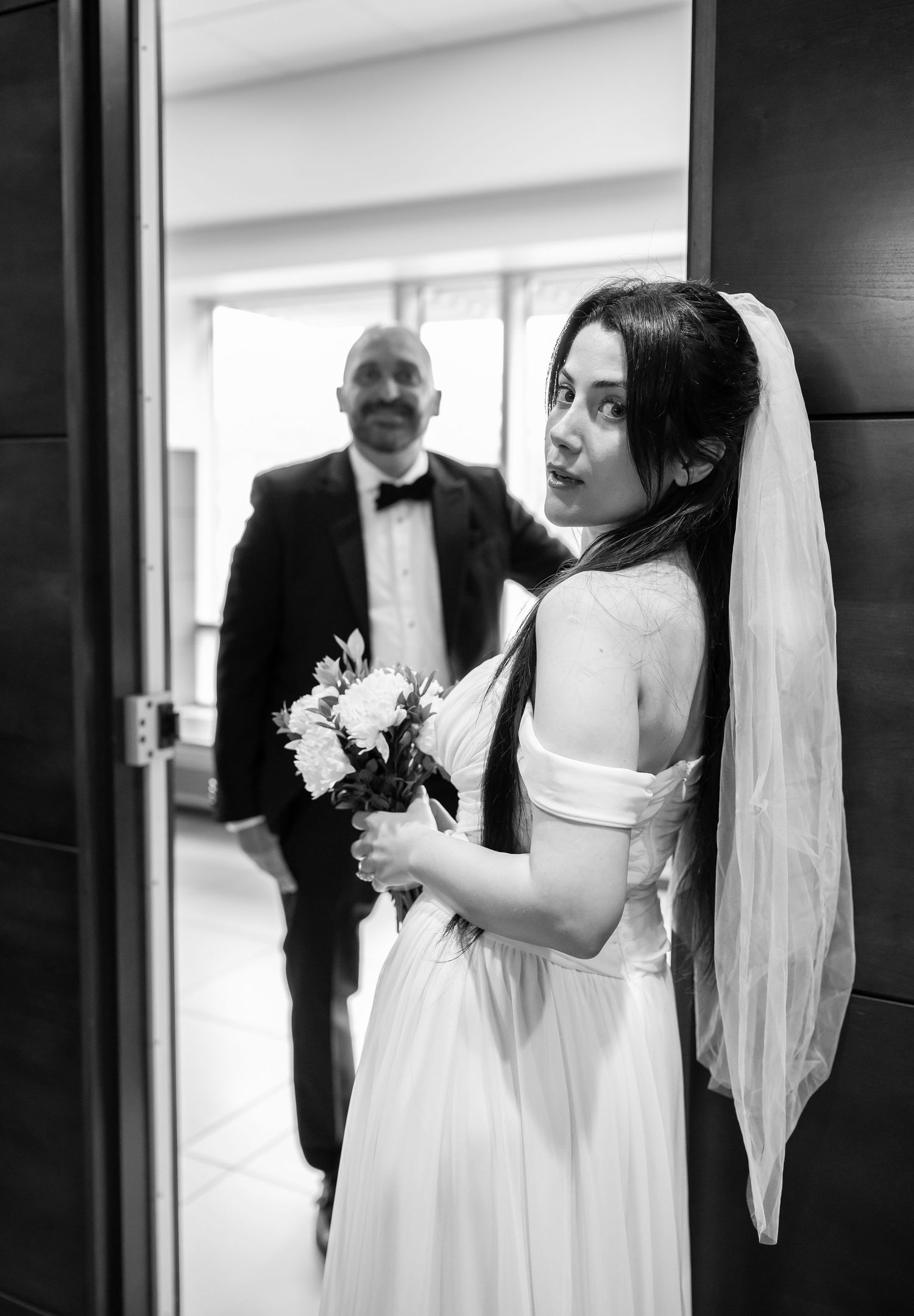 stylish urban portrait of a bride and groom leaning casually against the doorframe of the courthouse in Morgantown, WV before their wedding