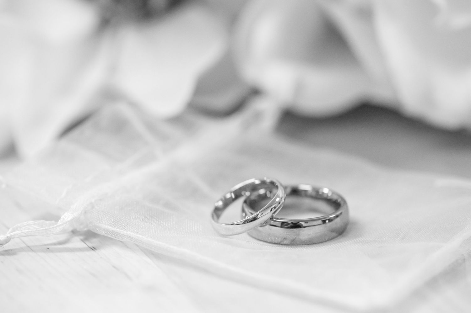 closeup shot of simple wedding rings lying in front of a bouquet of Magnolias at a small wedding in Morgantown, WV