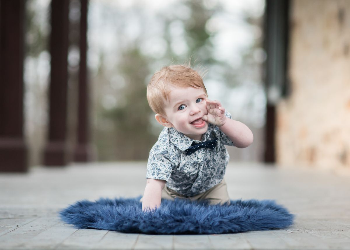 a little boy in a bowtie sits on a fluffy blue blanket on the porch of the Albert Gallatin house in Point Marion, PA