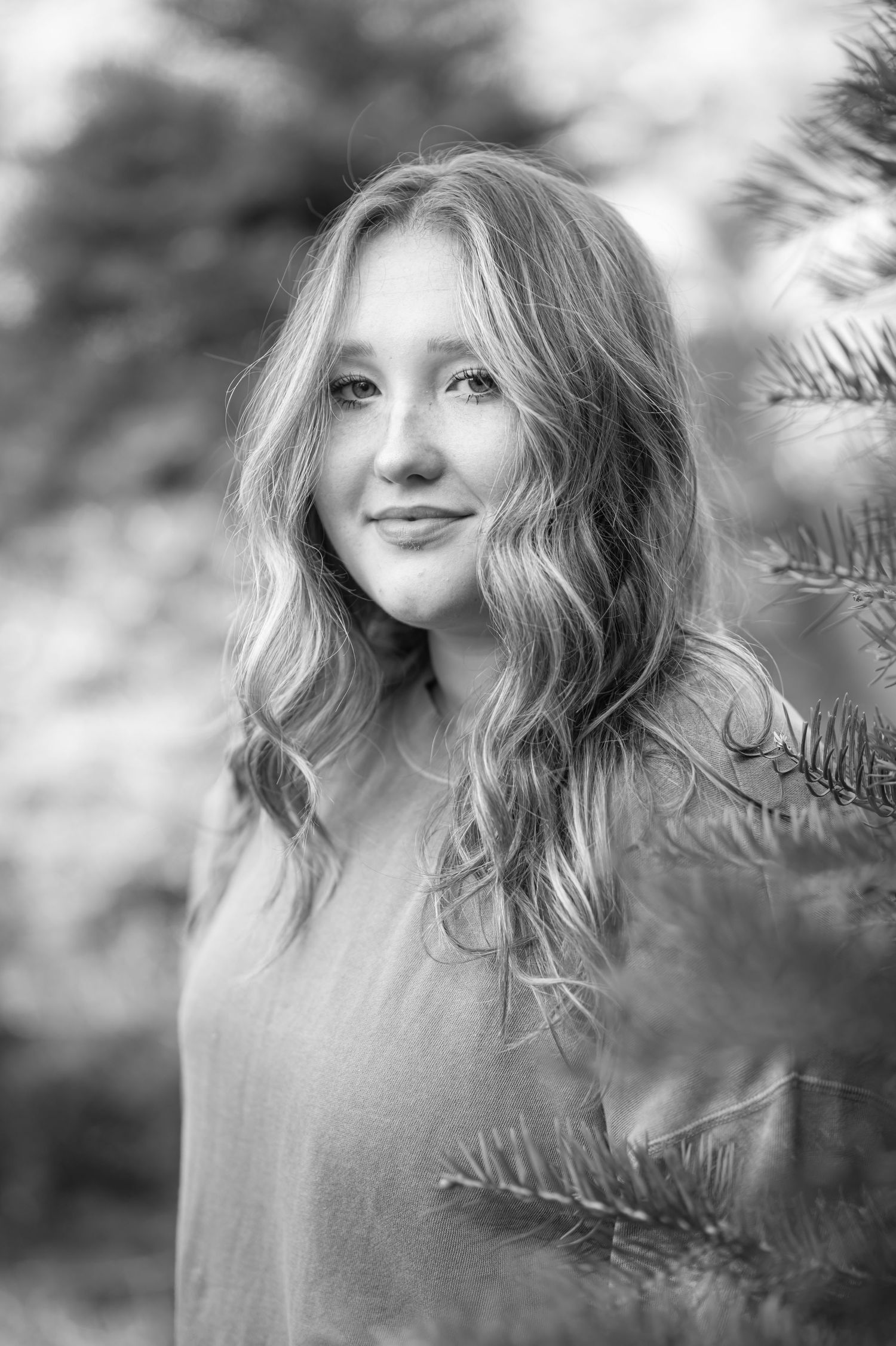 closeup portrait of a pretty young blonde in a sweater surrounded by Christmas trees at a tree farm in Fairmont, WV