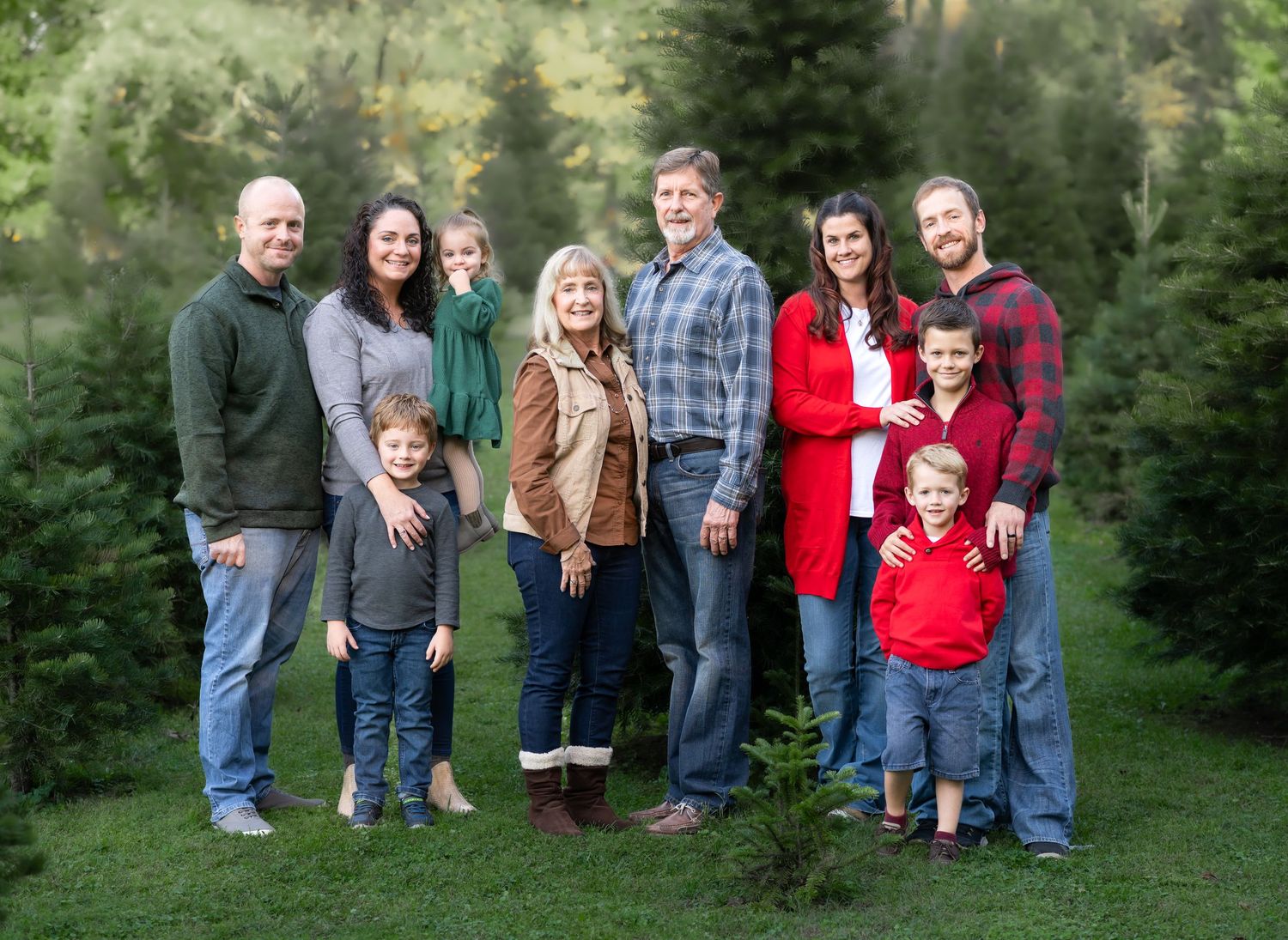 grandparents, children and grandchildren pose and smile together for a Christmas card picture on a Christmas tree farm in Fairmont, WV