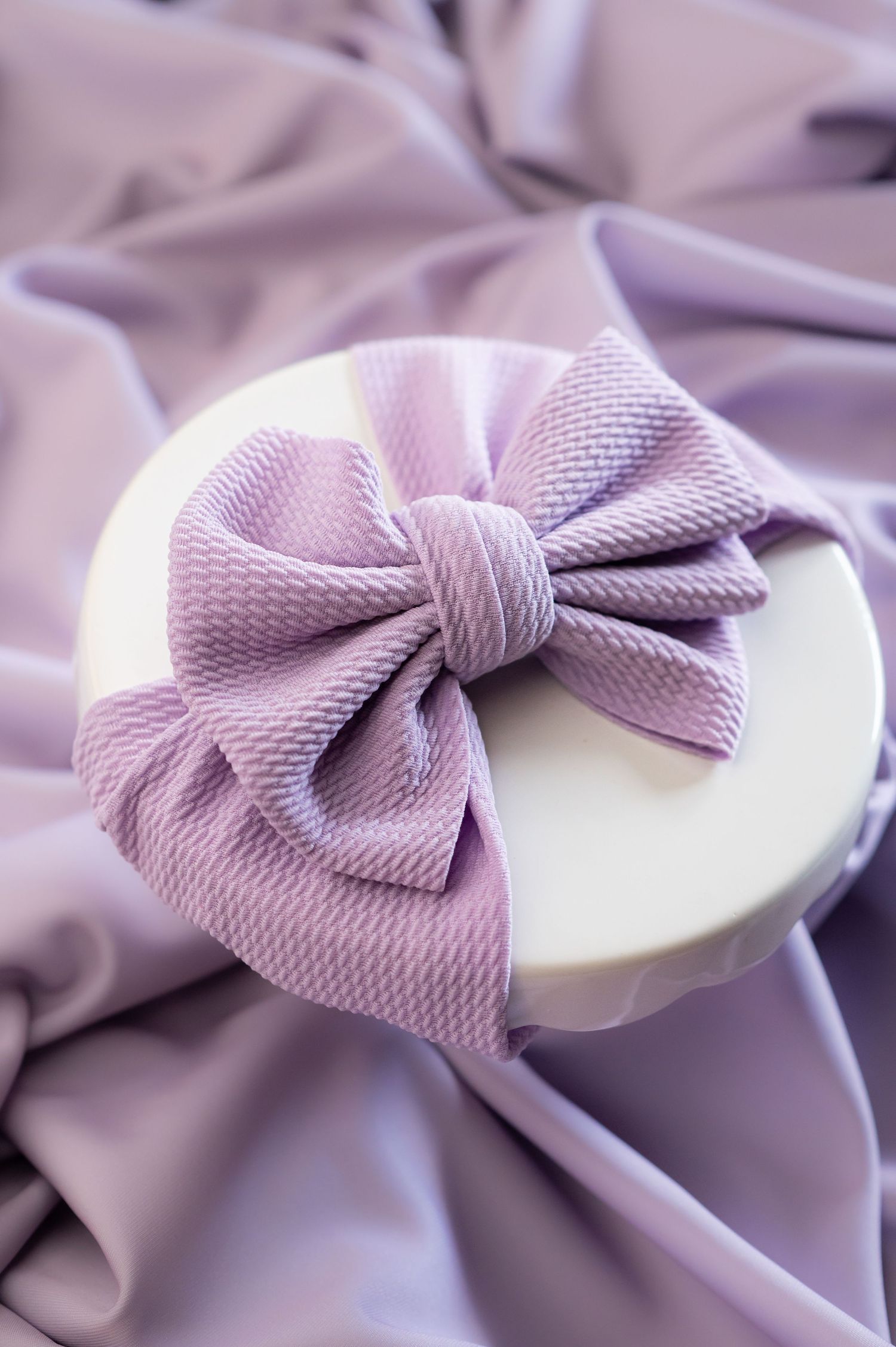 product image of a large lilac purple bow on a purple background
