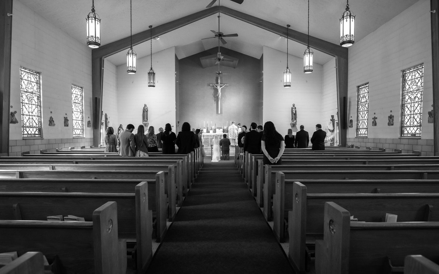 wide angle black and white image of the sanctuary of a Catholic church during a wedding