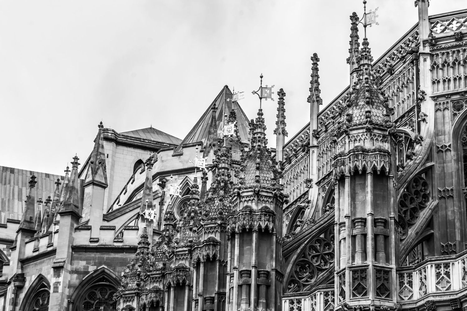 Black and white photo of ornate Gothic cathedral exterior with intricate stone carvings, spires, and arched windows.