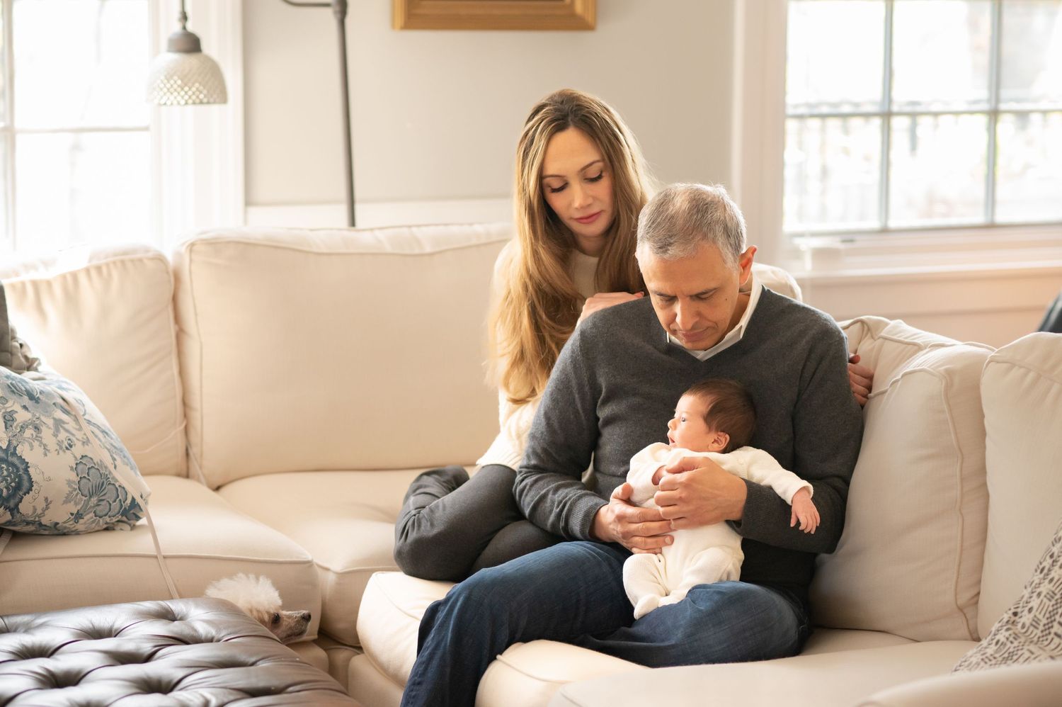 a mother and father pose on the couch with their newborn baby boy for a family portrait in their home in Morgantown, WV