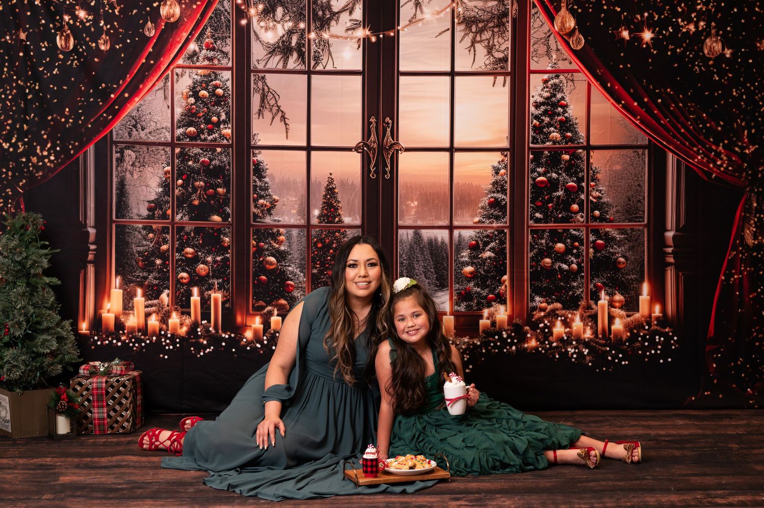 a mother and daughter in green Christmas dresses  pose for Christmas portraits on a beautiful Christmas background during mini sessions.