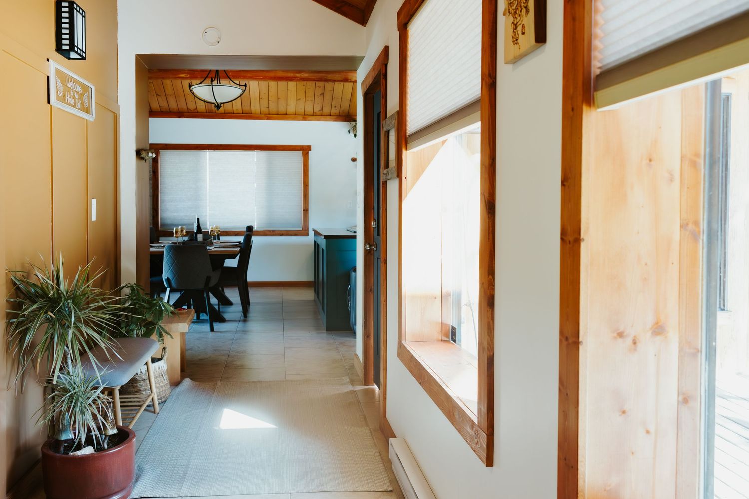 Bright hallway interior with wooden beams, potted plants and modern furniture.