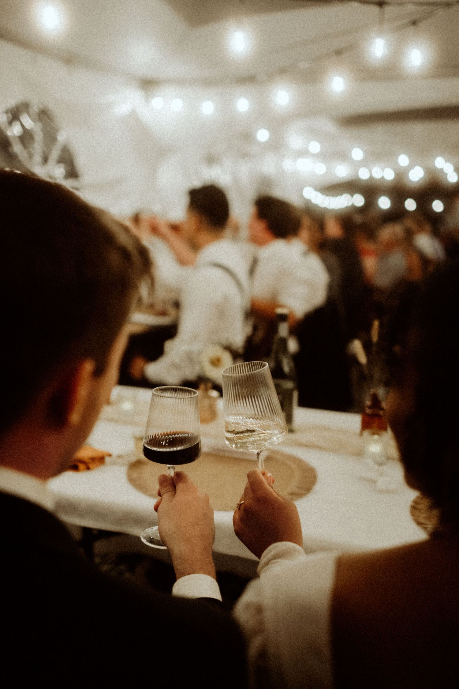 couple cheering at a wedding with wine glasses