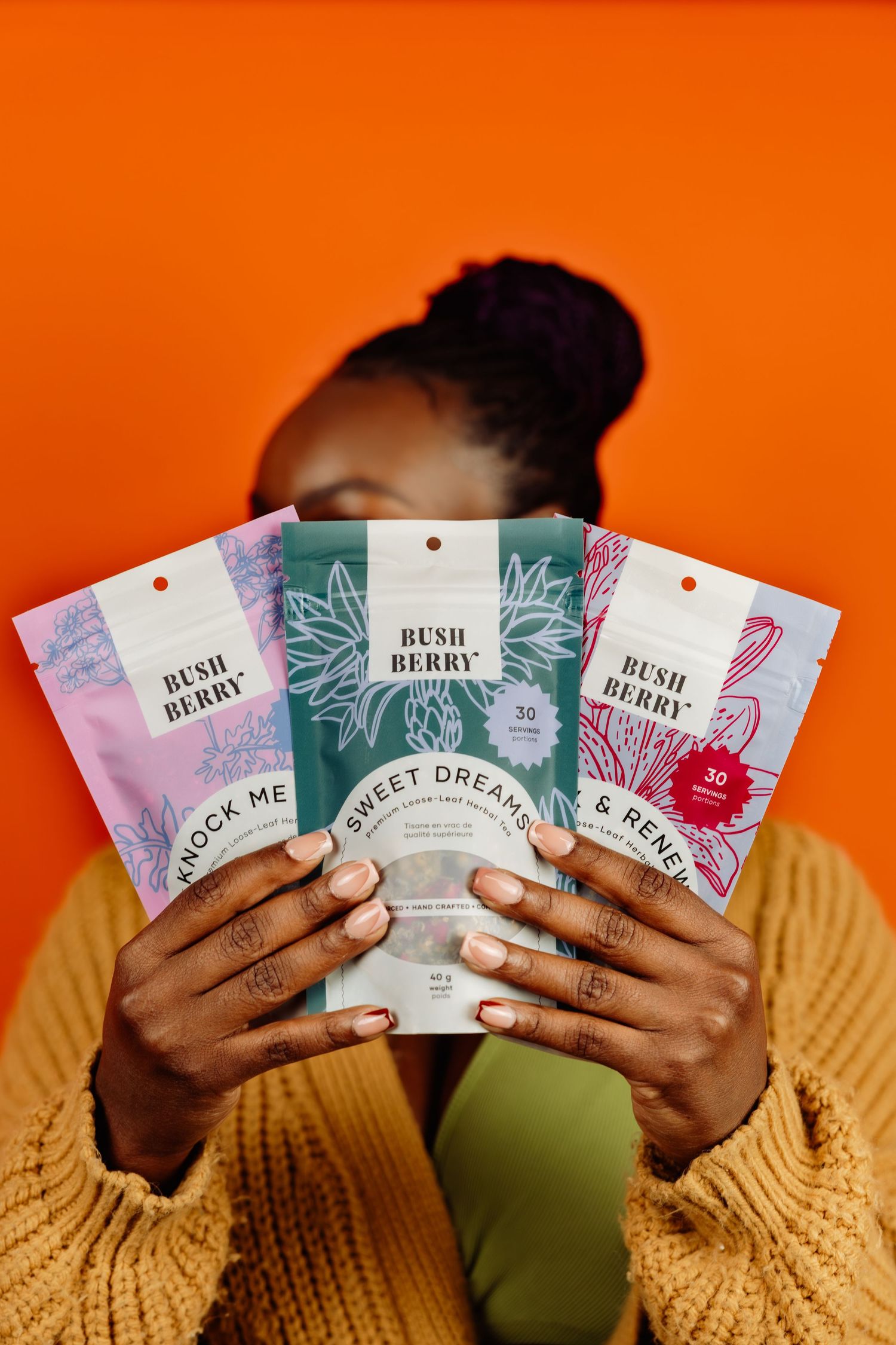 holding three packets of tea