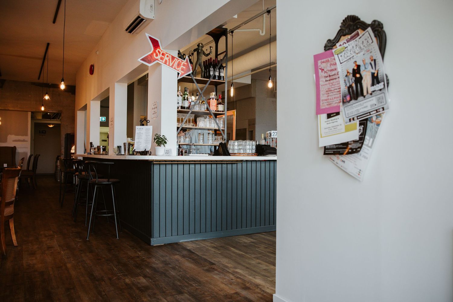 Modern bar interior with corrugated metal counter and wood flooring.
