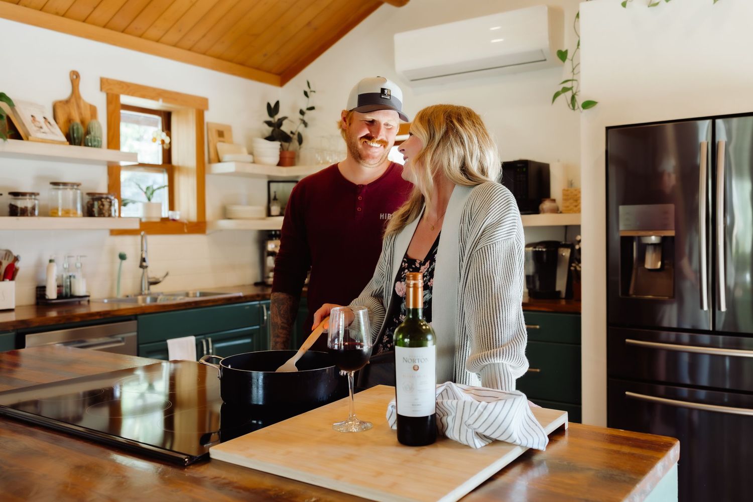 couple in the kitchen with wine beside them