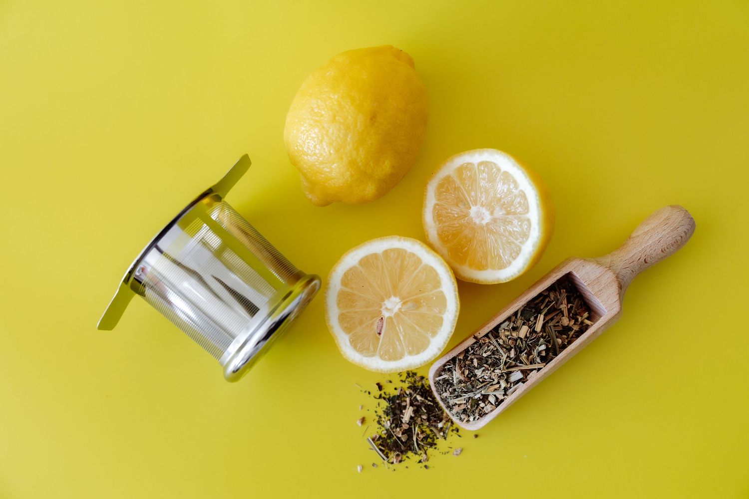lemon, tea infuser and dried tea leaves