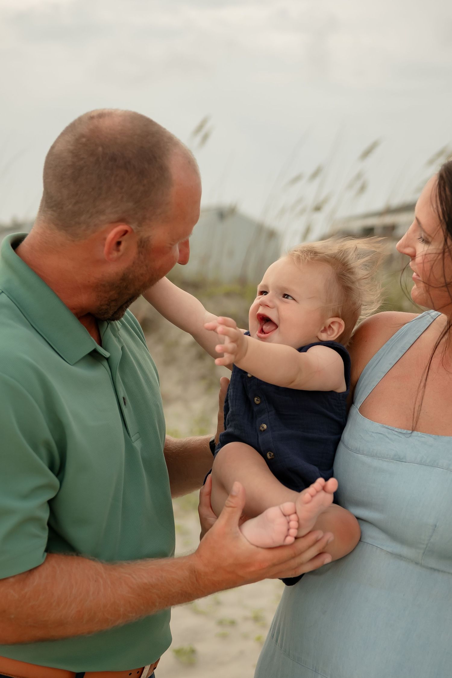 A sequence of joyful interactions between family members on a breezy beach day.