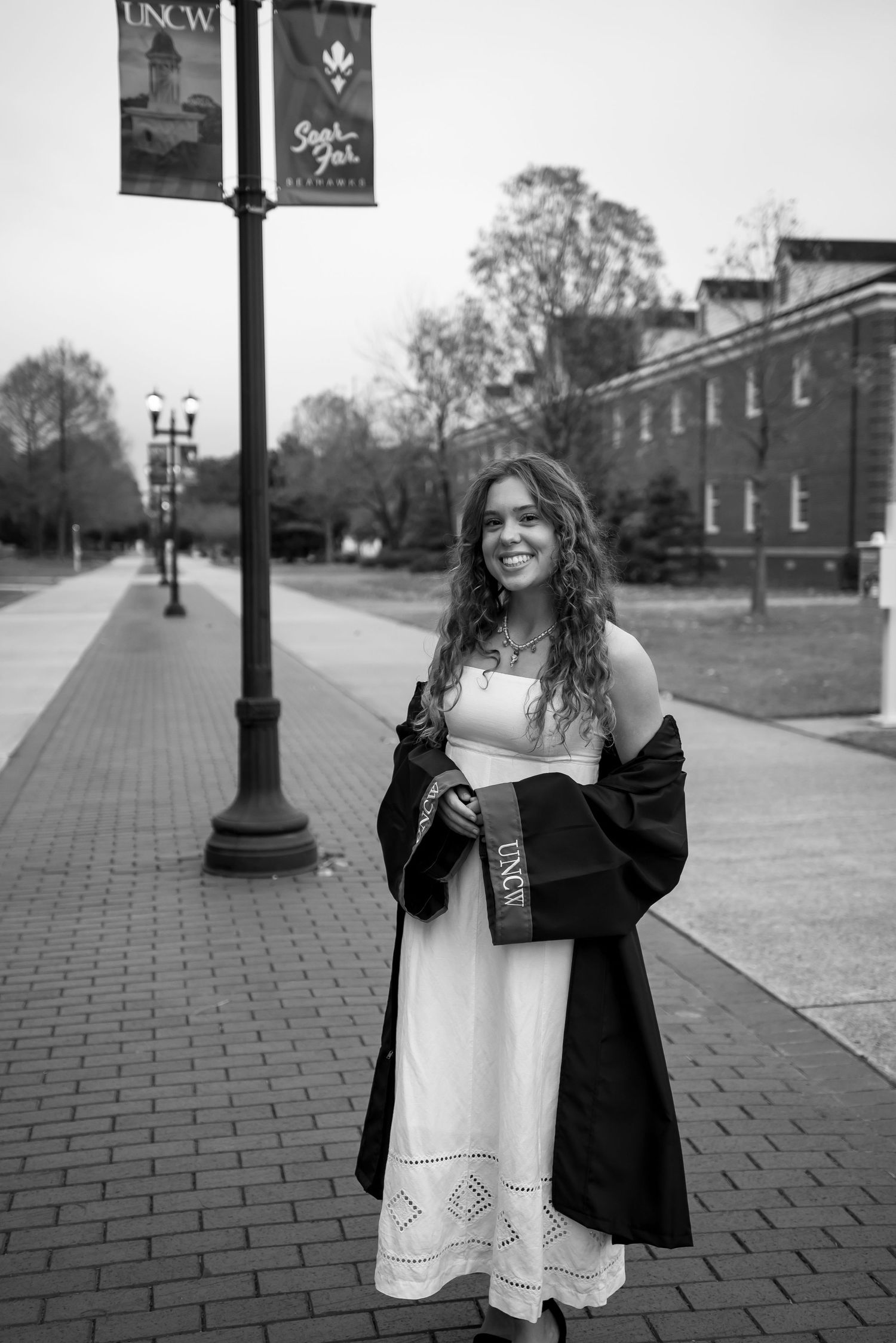 A joyful graduation photo sequence showing someone in a black gown and white dress on campus.