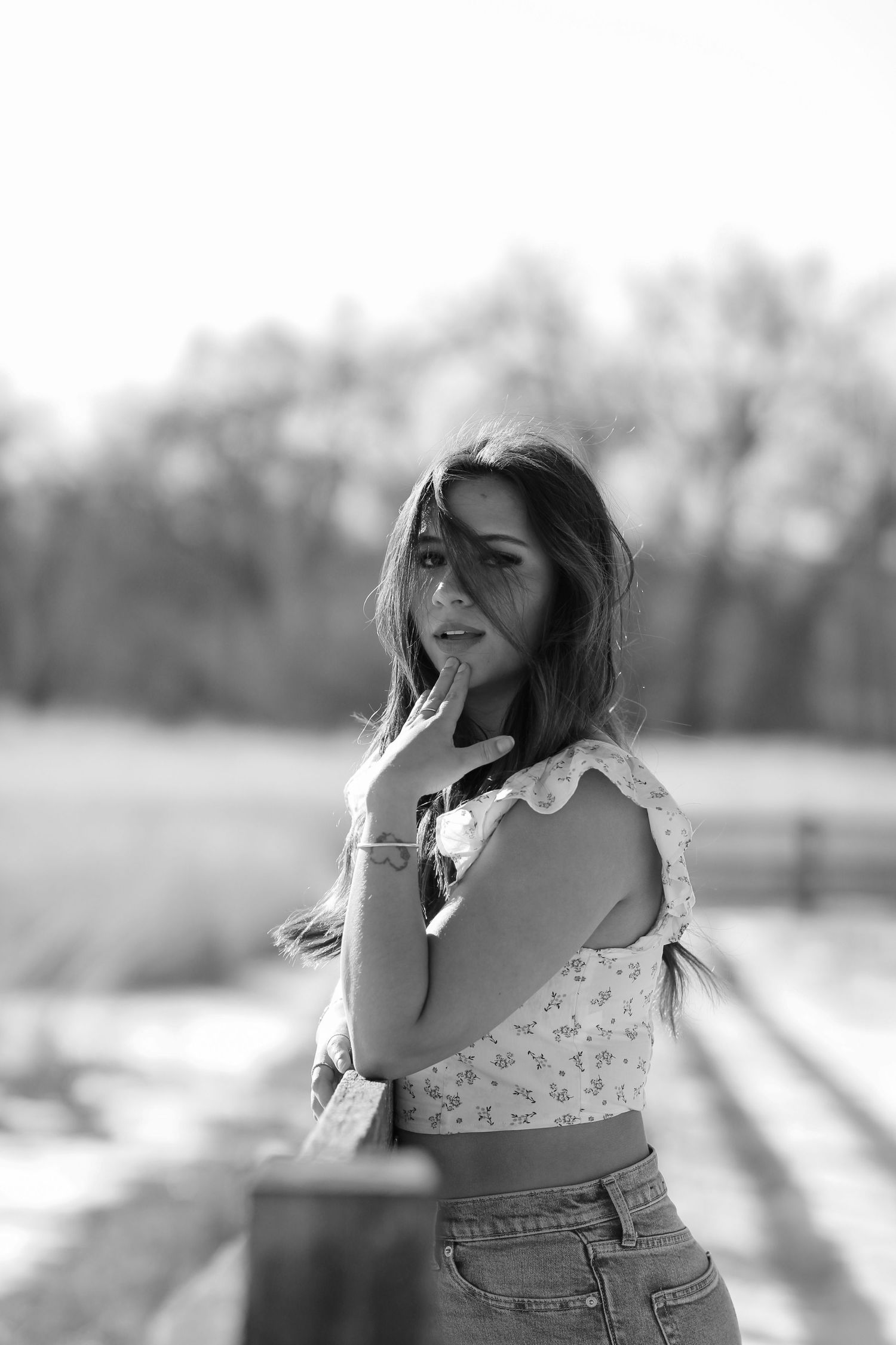 Black and white portrait series in floral top with candid expressions.