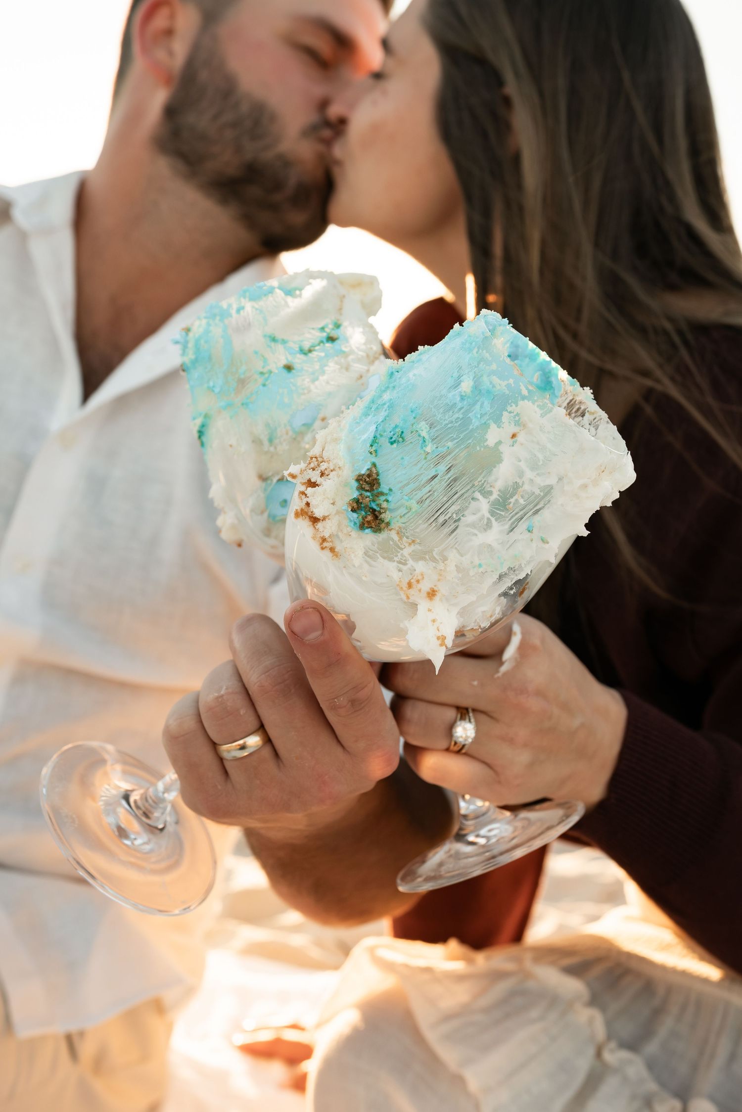 Close-up of hands holding blue-tinted ice cream treats during a beach date.