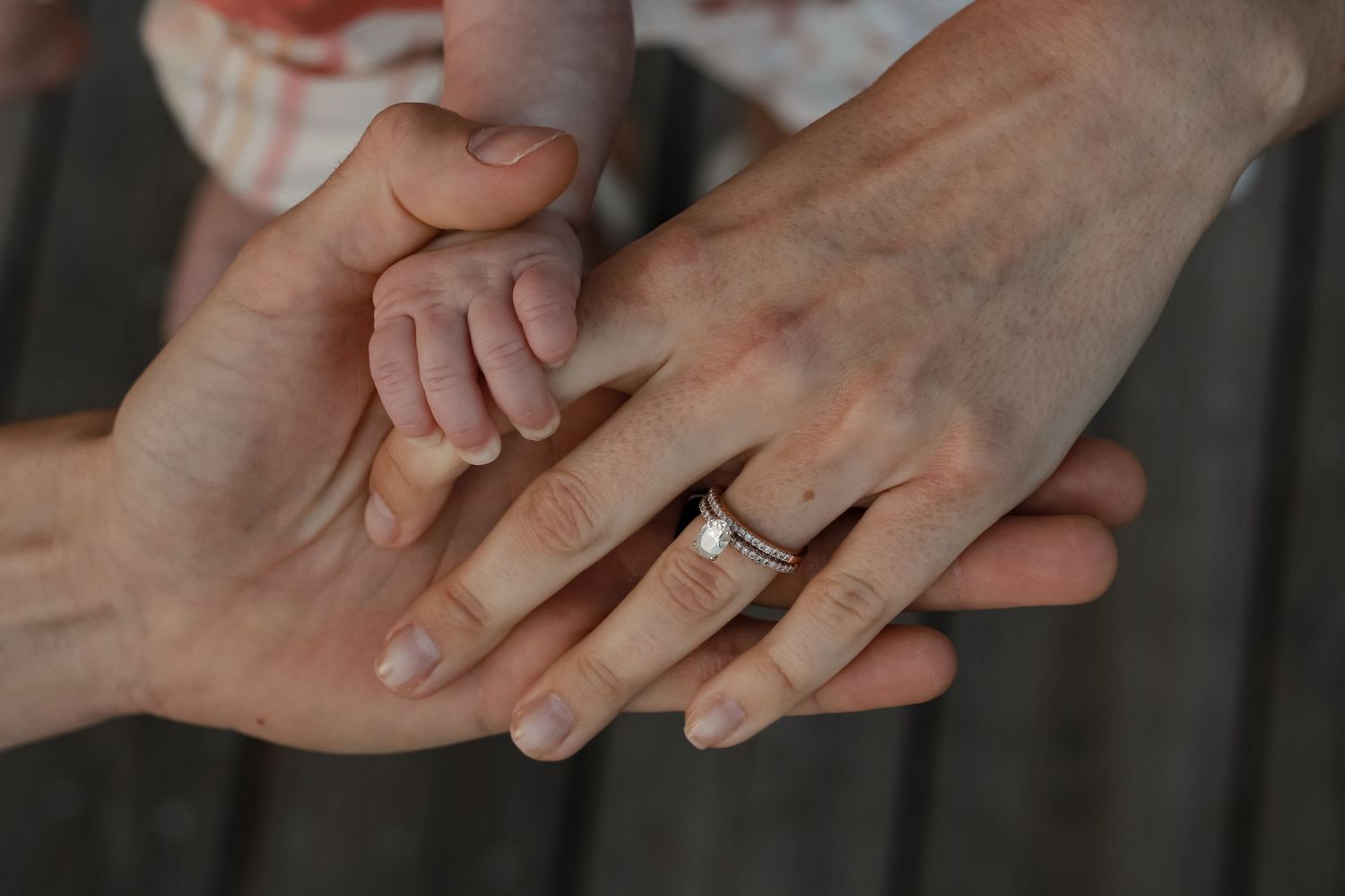Close-up of hands with engagement rings showing affection and love.