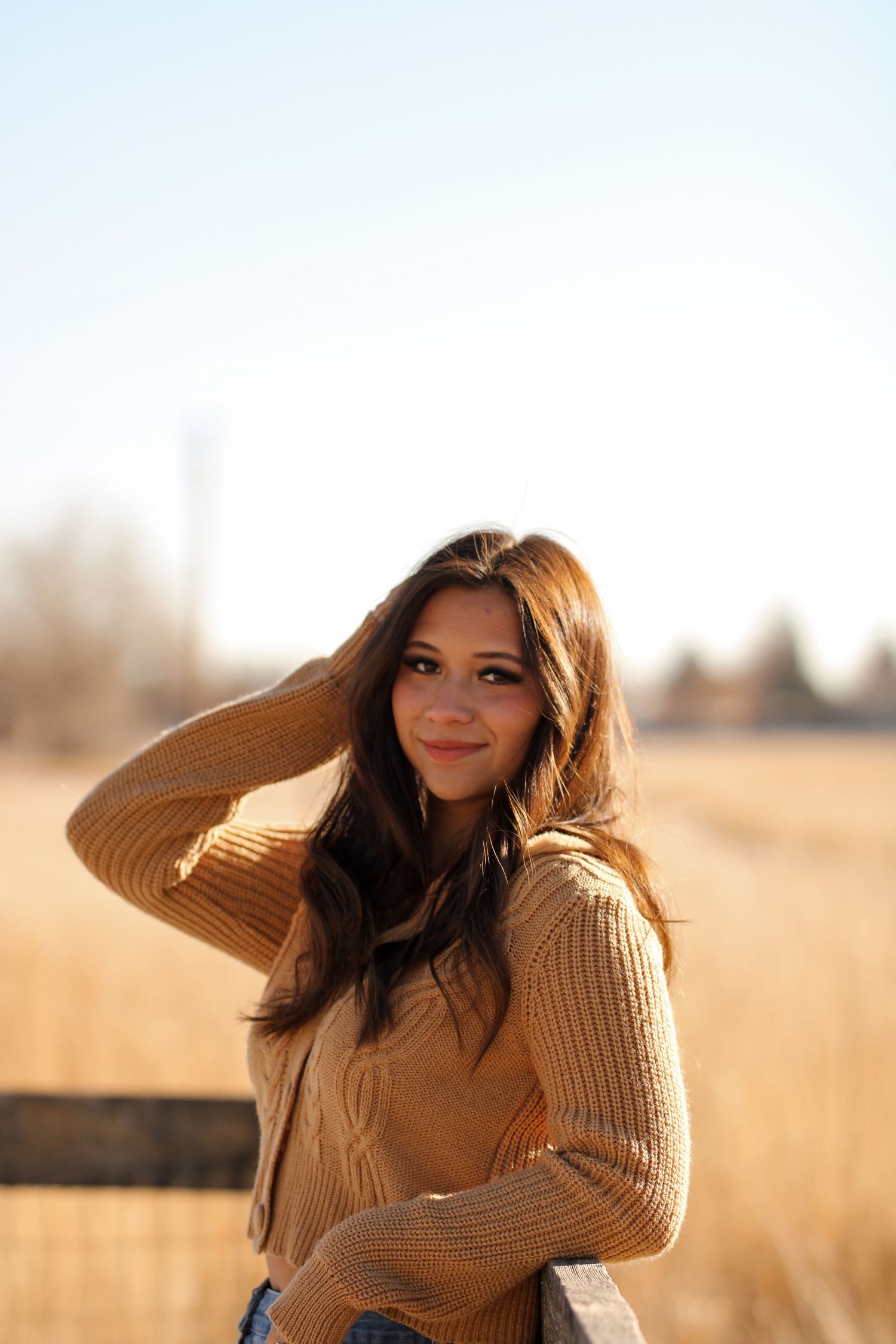 Golden hour portrait session in a field wearing cozy knit sweater.