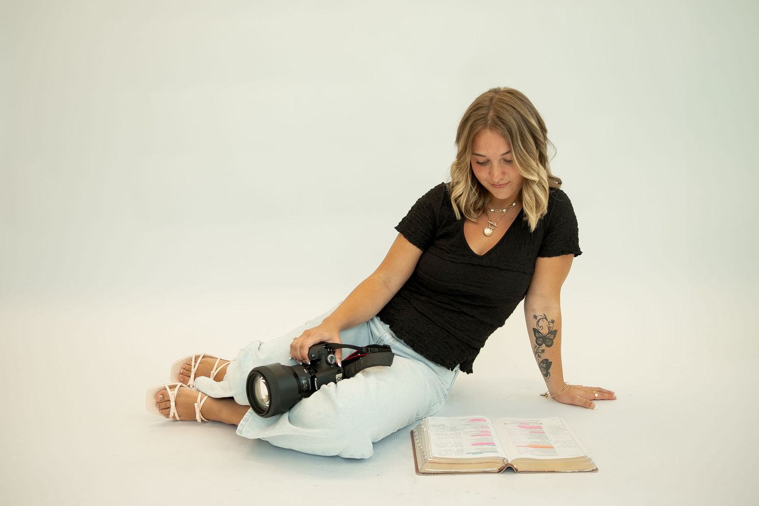 A photographer poses with camera and books in various casual positions against white background.