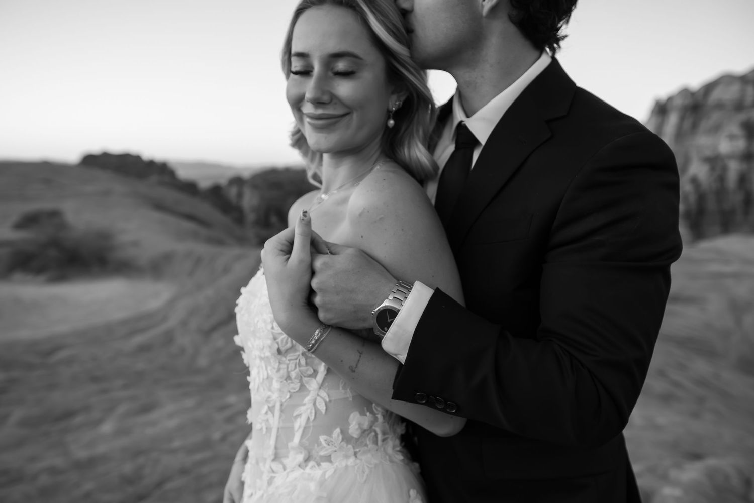 Black and white wedding portrait showing tender moment between newlyweds.