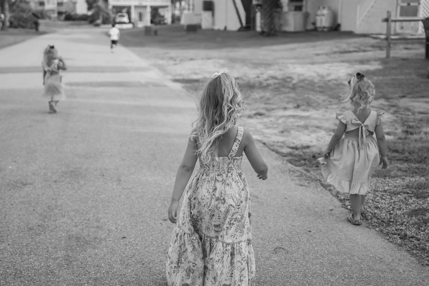 Black and white vintage photograph showing children playing outdoors on a sunny day.