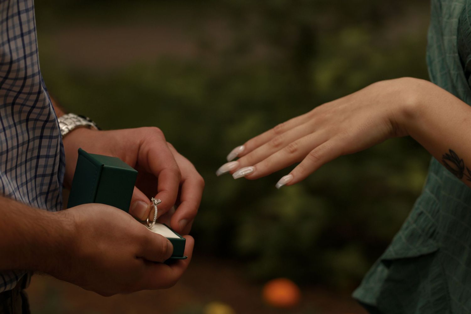 Close-up sequence of hands exchanging an engagement ring during a romantic proposal.