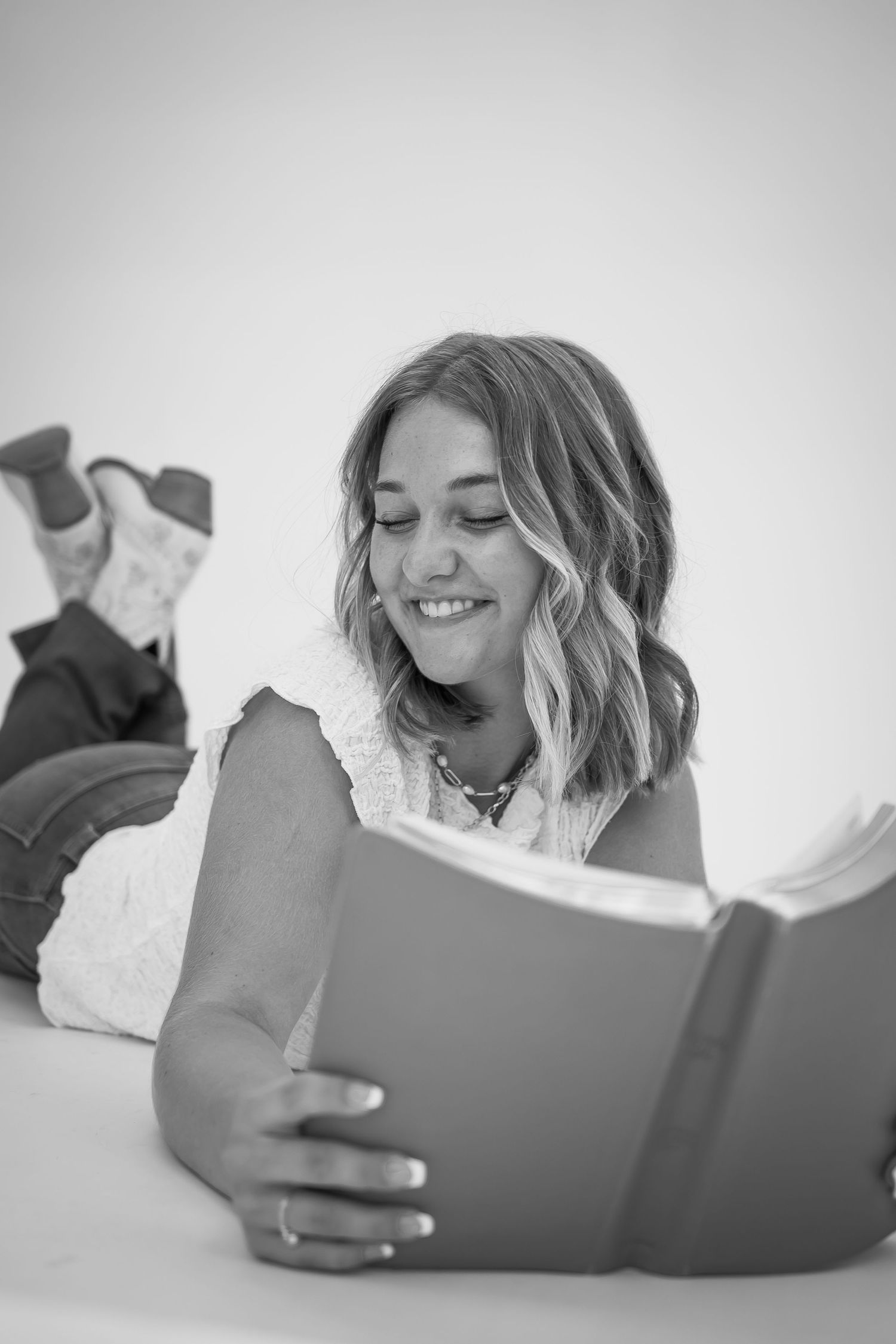 A series of black and white photos showing someone reading and enjoying a book.