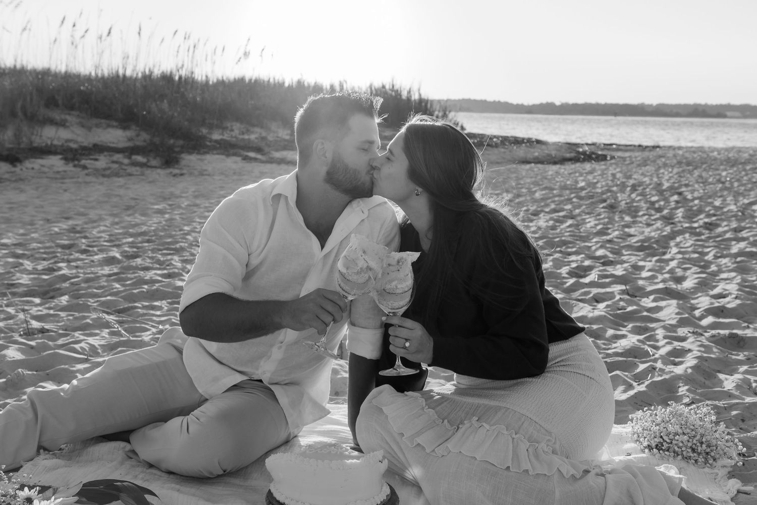 Black and white photo of a romantic beach picnic at sunset.