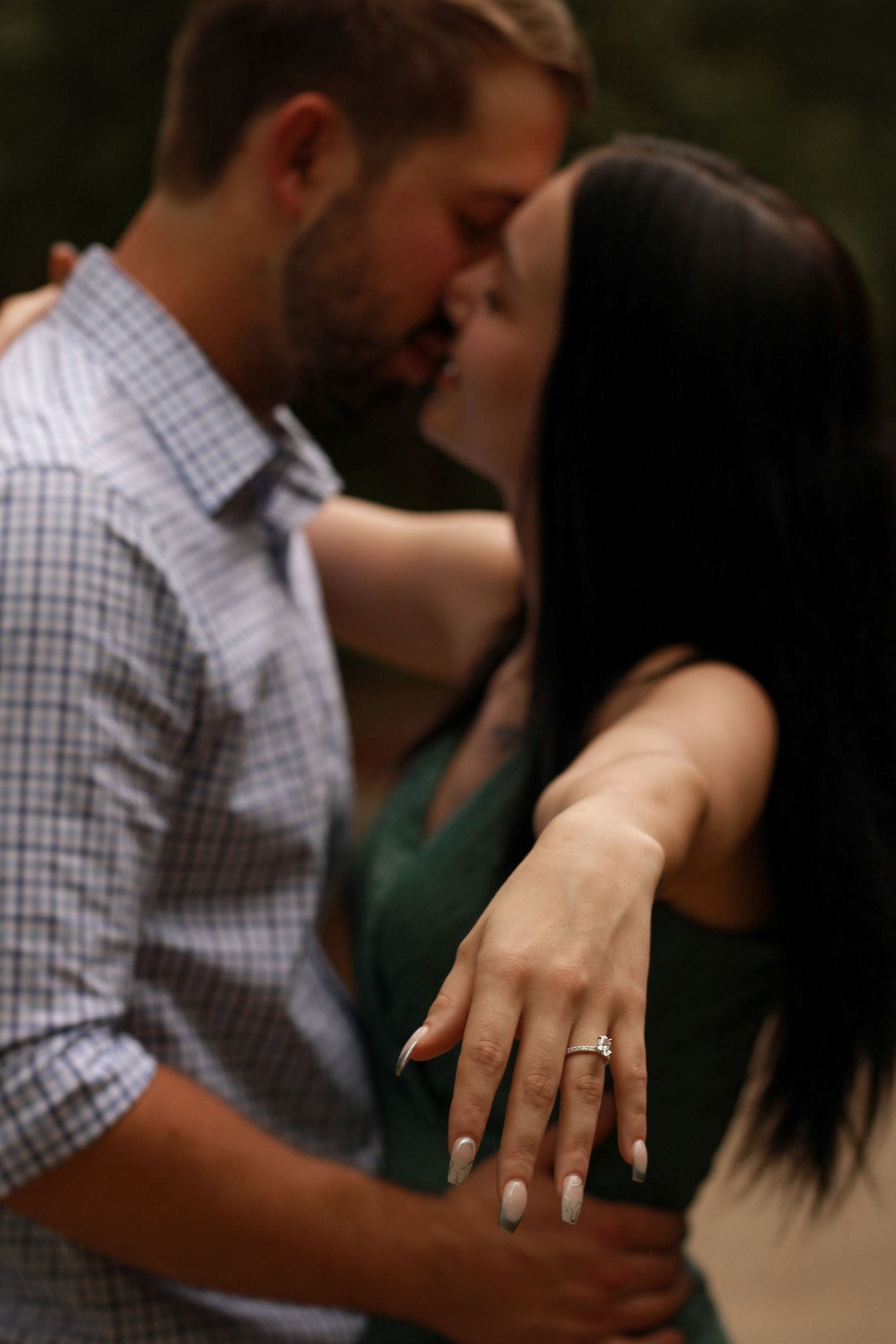 Close-up shot of hands with an engagement ring during an intimate moment.