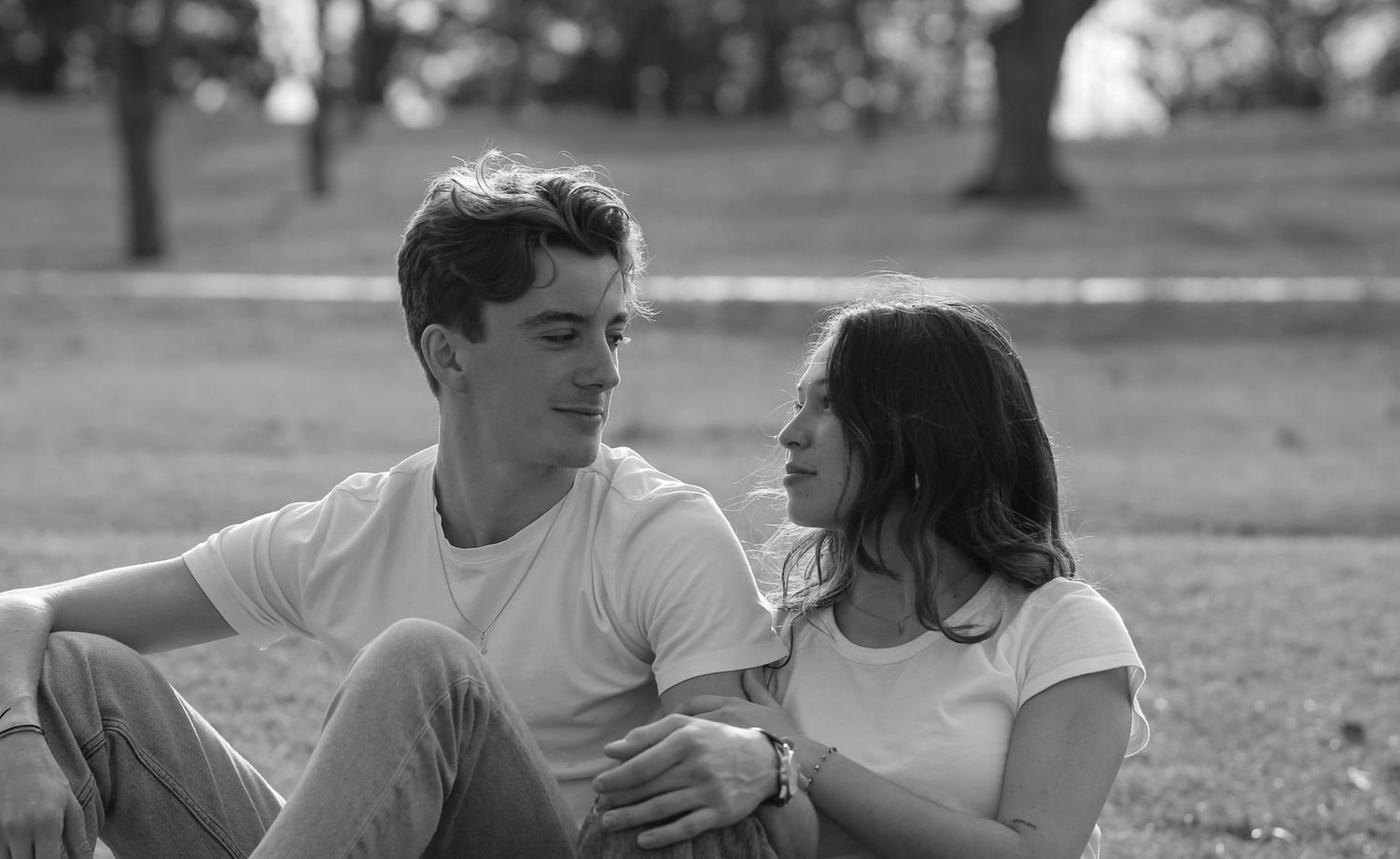 A couple sharing an intimate moment outdoors in black and white.