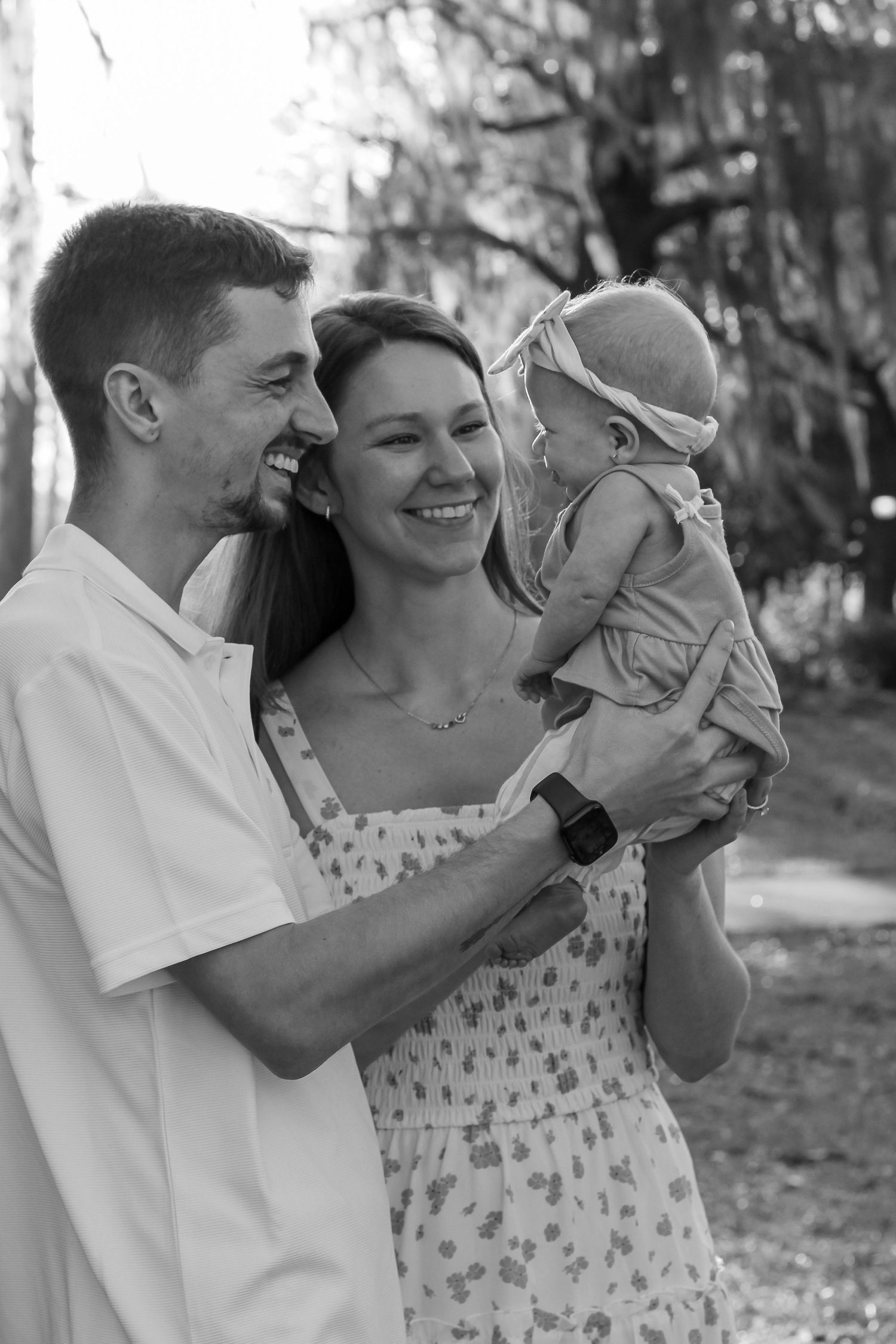A series of candid black and white family photos showing joyful moments with a baby.