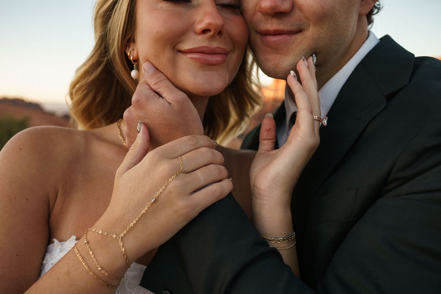 Intimate close-up wedding portraits against a desert landscape backdrop.