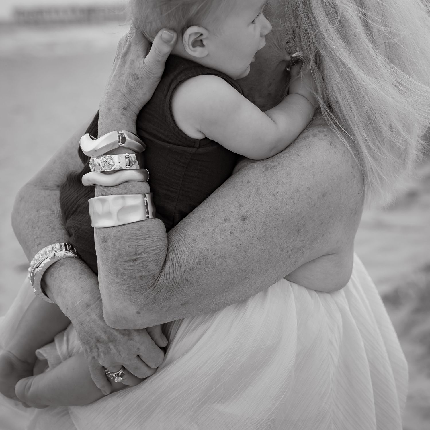 Intimate black and white photographs showing tender embraces on the beach.