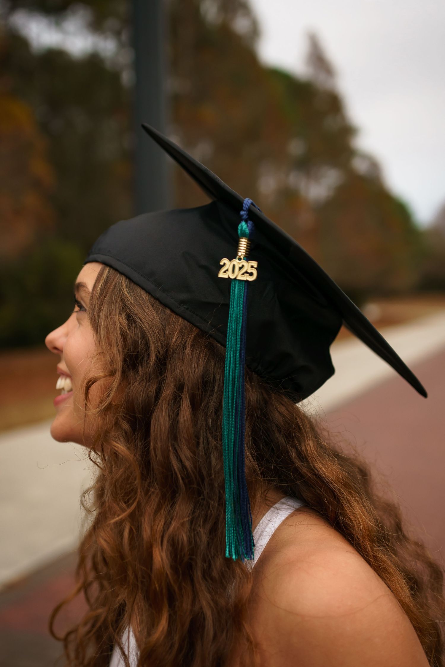 Close-up shots of a graduation cap with 2025 and teal tassel against an autumn background.
