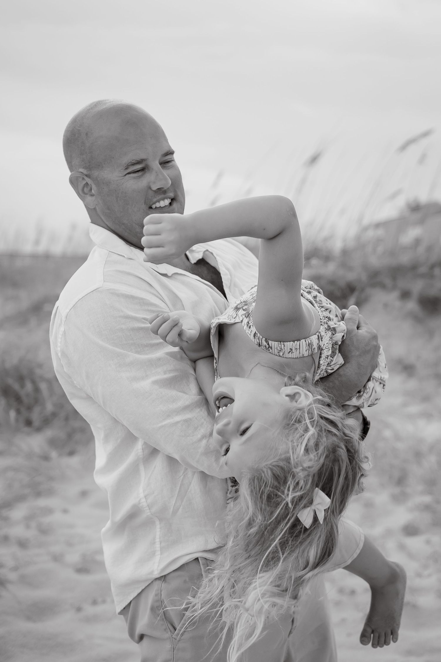 Black and white photos capturing playful moments between family members on the beach.