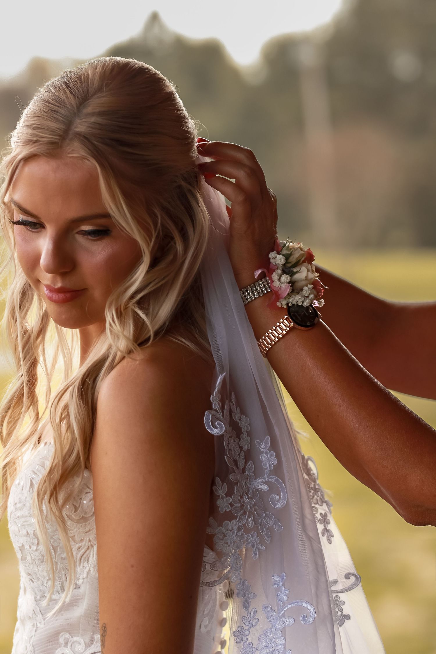 Close-up shots of a bride getting ready, showing details of her veil and blonde hair styling.