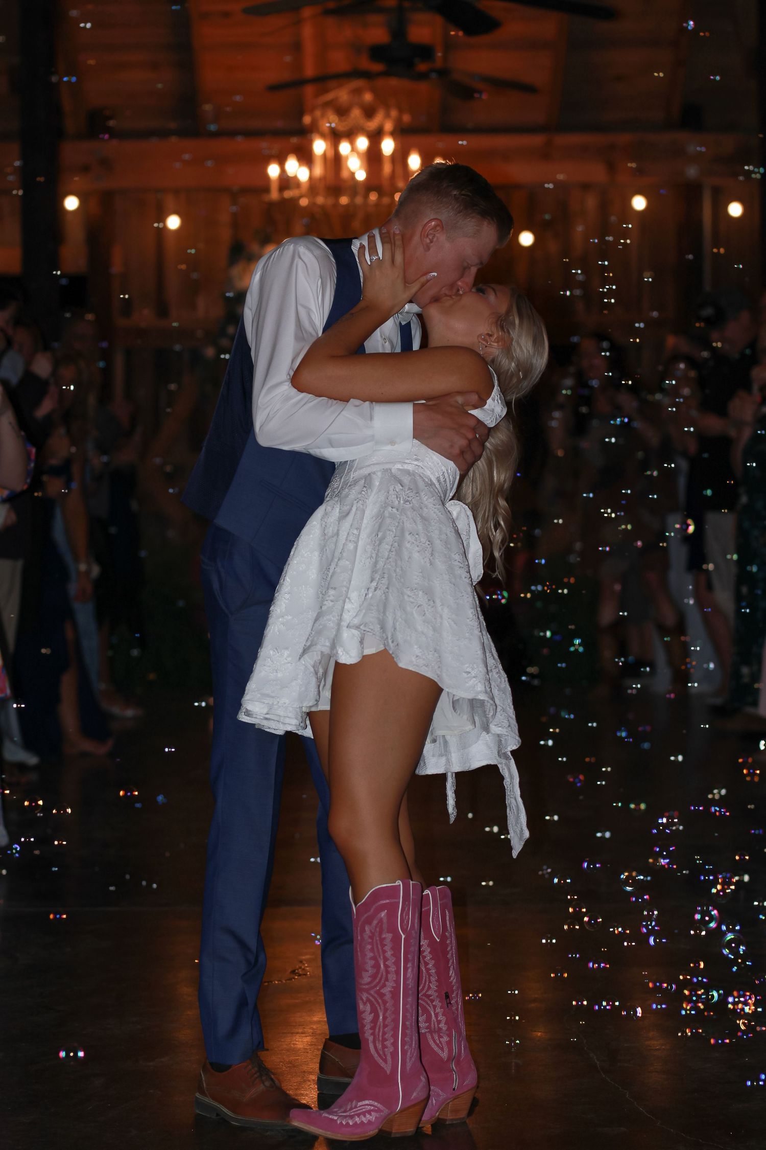 A couple dancing at a wedding reception with bubbles floating around them.