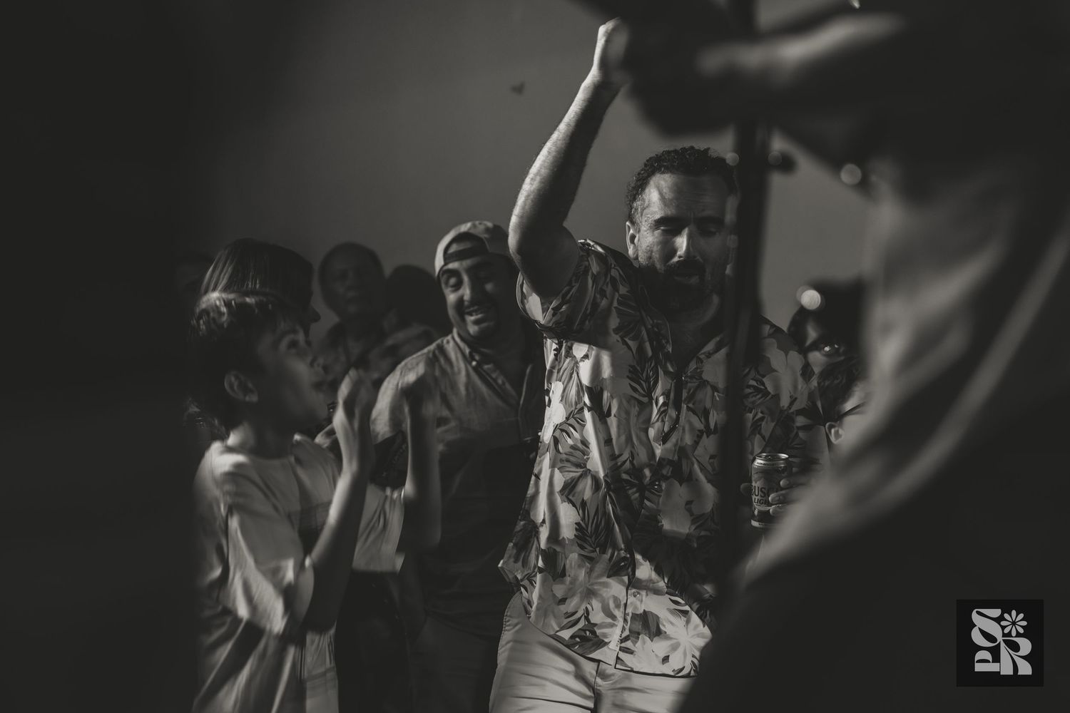 Black and white photo of people dancing and enjoying themselves at a high-energy club or party event.